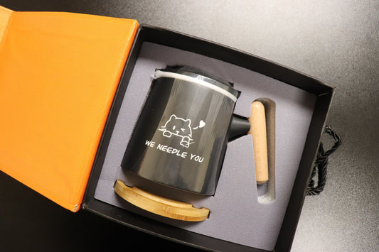 We Needle You ceramic mug displayed inside its open orange gift box